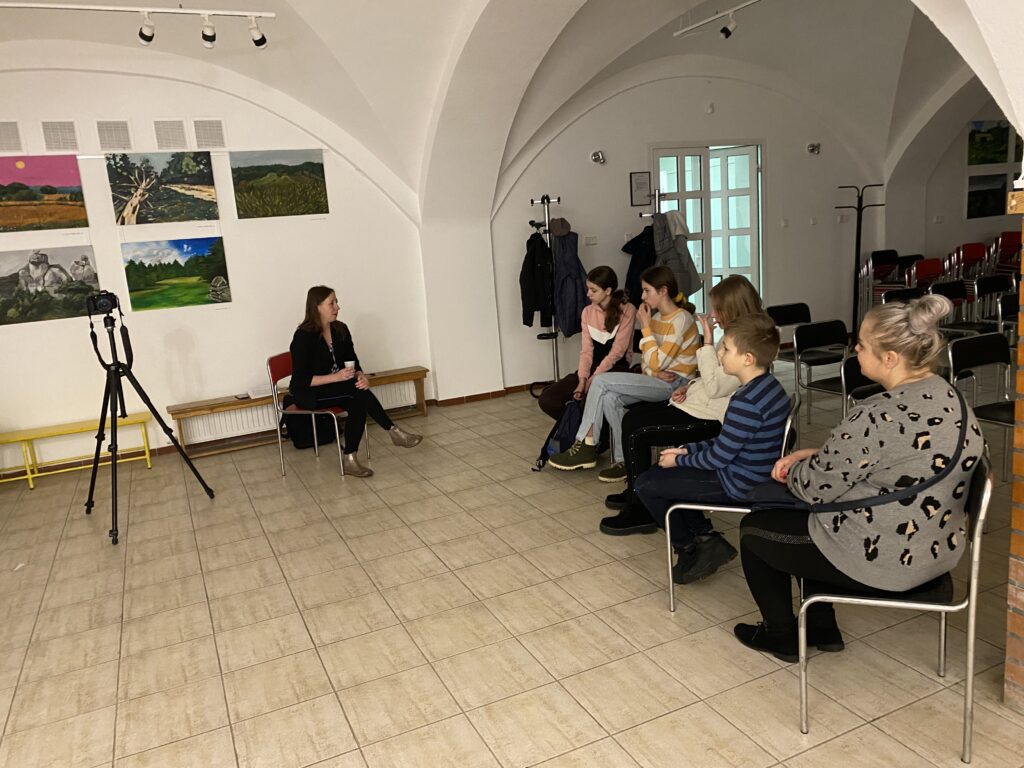 Pani Maria Bitka w Galerii Ogniska plastycznego oraz pięcioro słuchaczy wykładu.